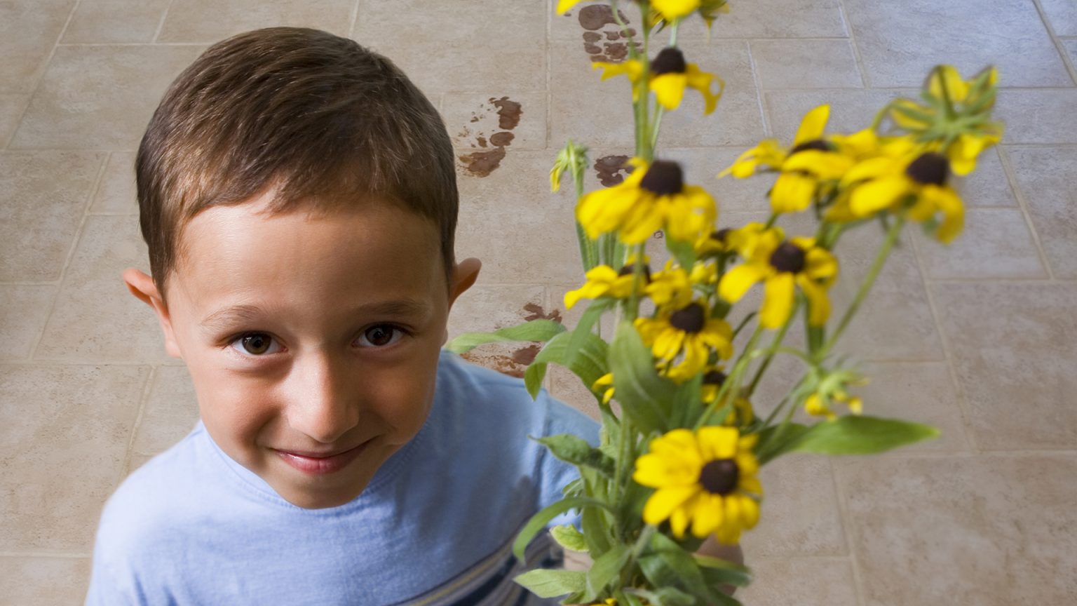 A little boy with freshly-picked flowers for mom.