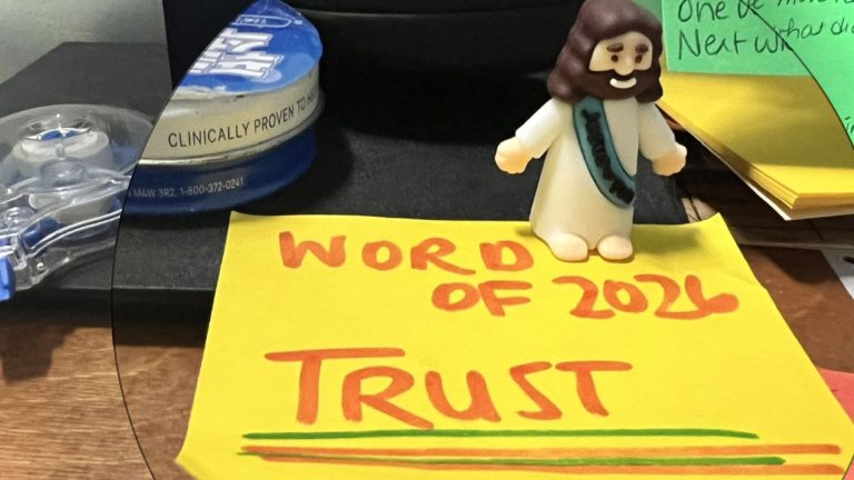yellow post it note on desk with the word trust on it as the word of the year