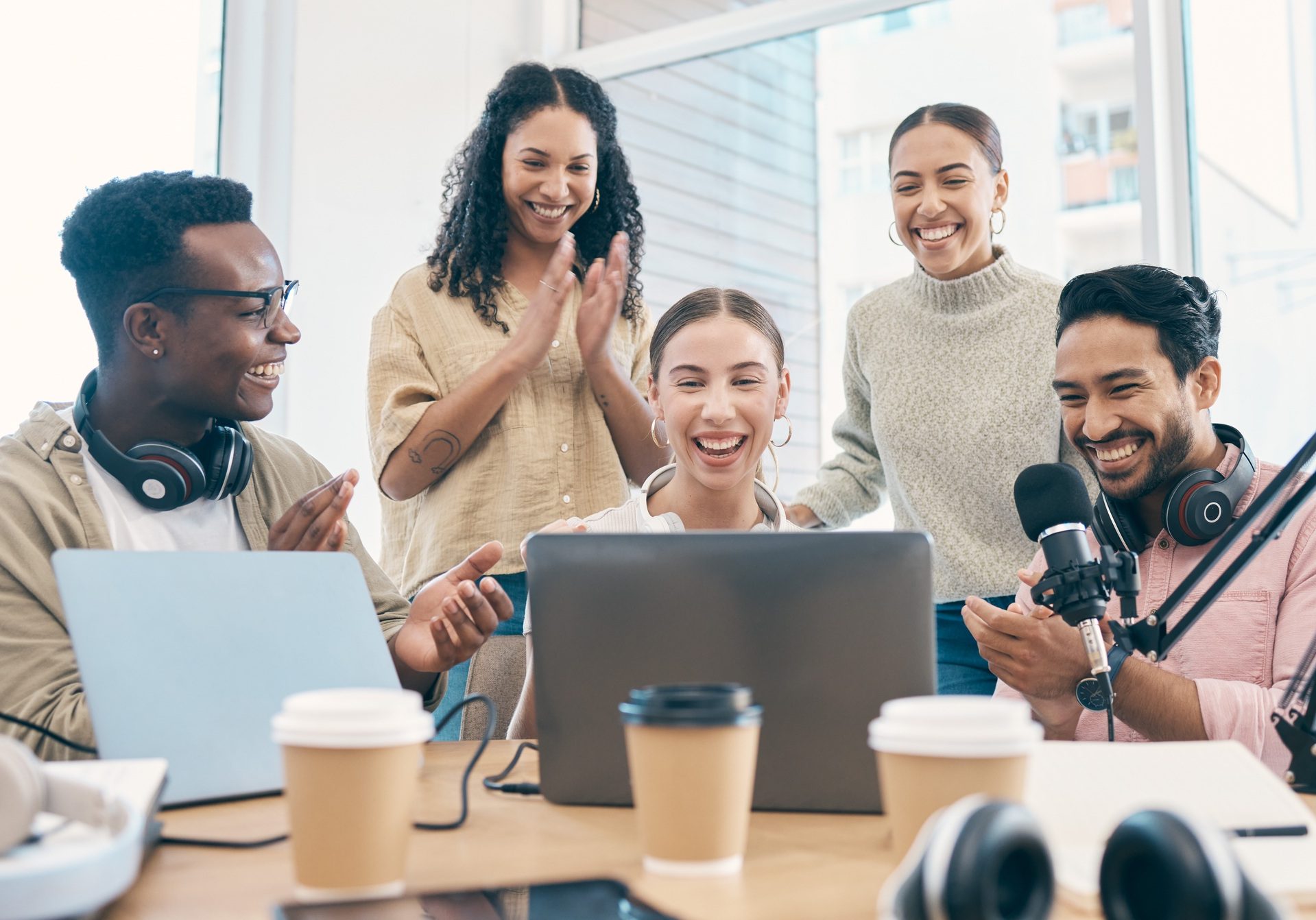 Celebration, radio group and people with applause, laptop and prize with internet, giveaway and exc